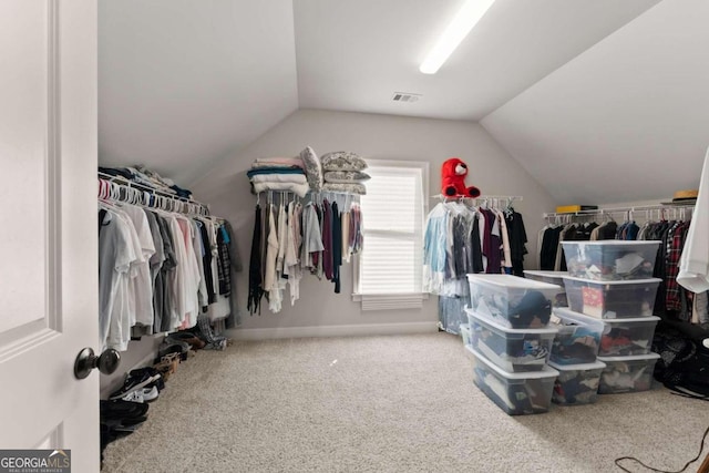 walk in closet featuring carpet flooring and lofted ceiling