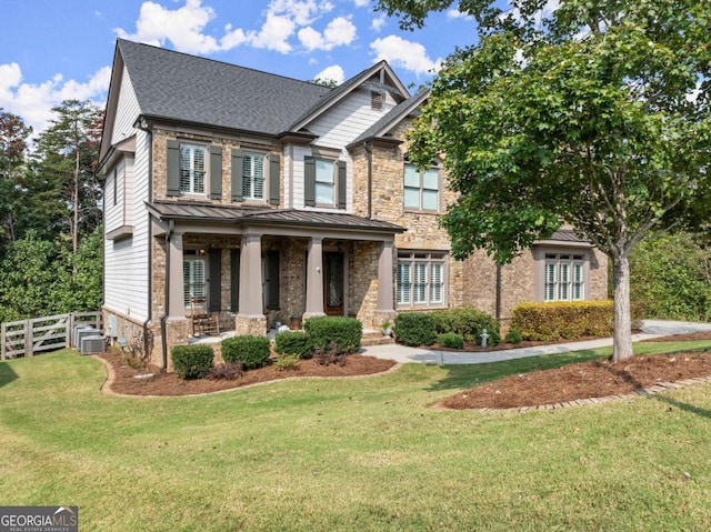 craftsman house with a porch, a front yard, and cooling unit