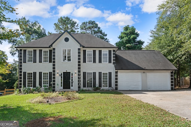 colonial house with a front yard and a garage