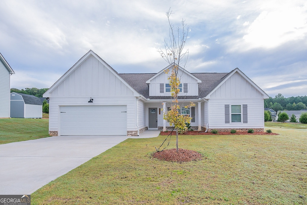 view of front of home featuring a front yard, covered porch, and a garage