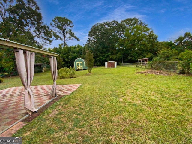 view of yard featuring a storage shed and a patio area