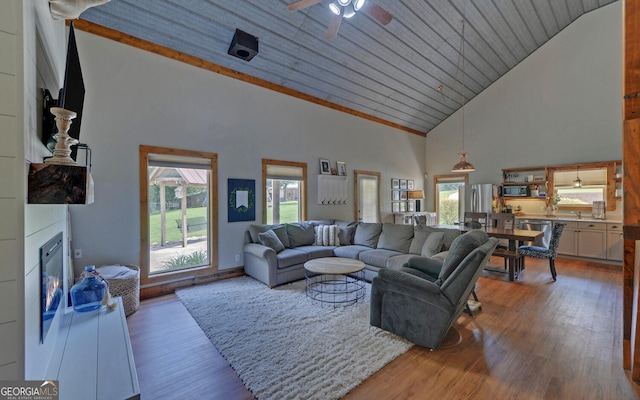 living room with hardwood / wood-style flooring, ceiling fan, wood ceiling, and high vaulted ceiling