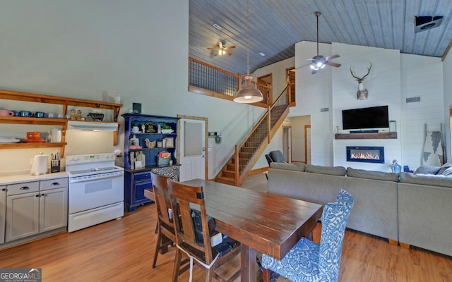 dining area with light hardwood / wood-style flooring, high vaulted ceiling, ceiling fan, and wood ceiling