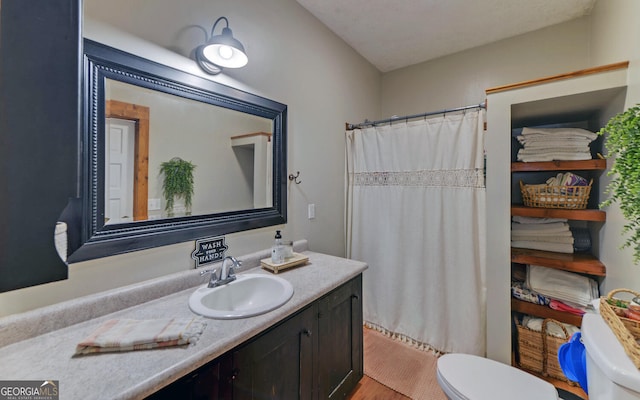 bathroom featuring curtained shower, hardwood / wood-style flooring, vanity, and toilet