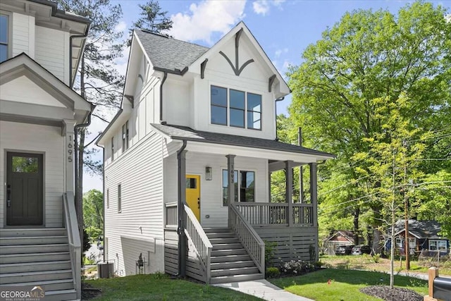 view of front of home with a front yard, a porch, and central air condition unit