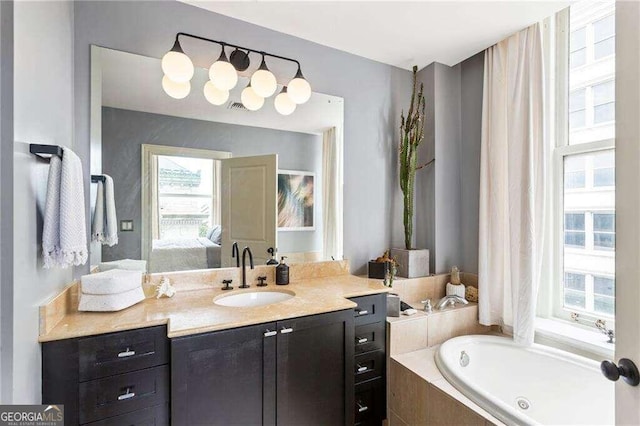 bathroom with tiled bath and vanity