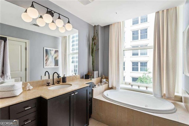 bathroom featuring vanity and tiled bath