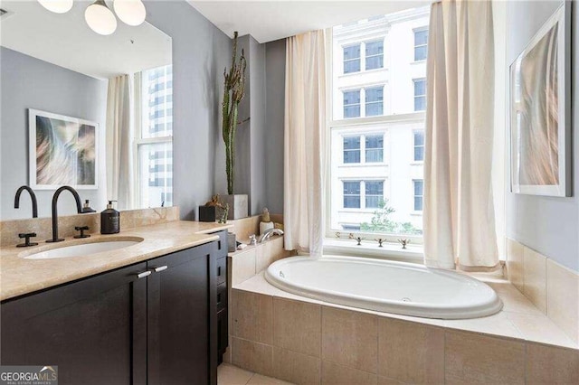 bathroom with tiled tub and vanity