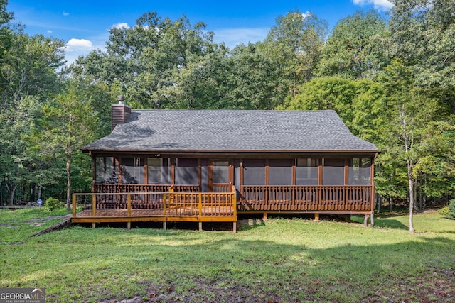 rear view of property with a lawn and a sunroom