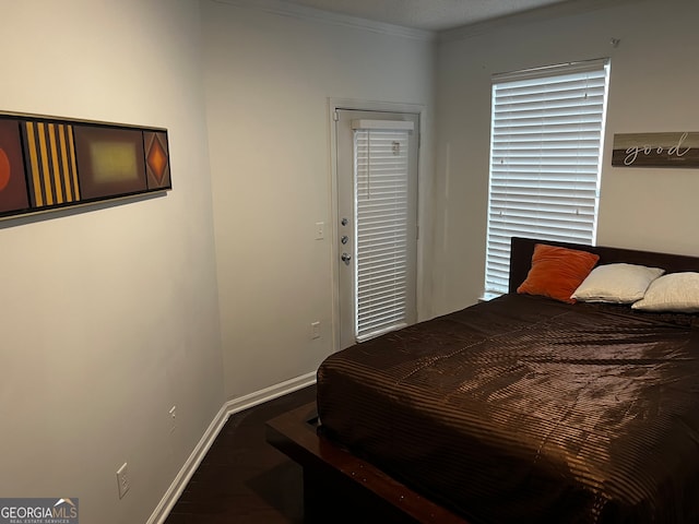 bedroom featuring a textured ceiling, dark hardwood / wood-style floors, and ornamental molding