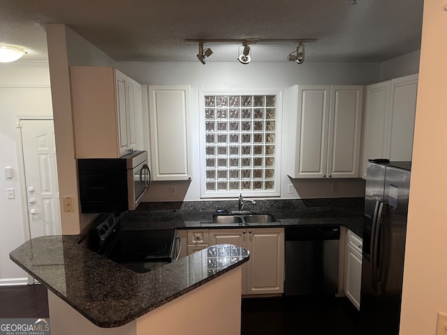 kitchen featuring white cabinetry, sink, stainless steel appliances, kitchen peninsula, and a textured ceiling