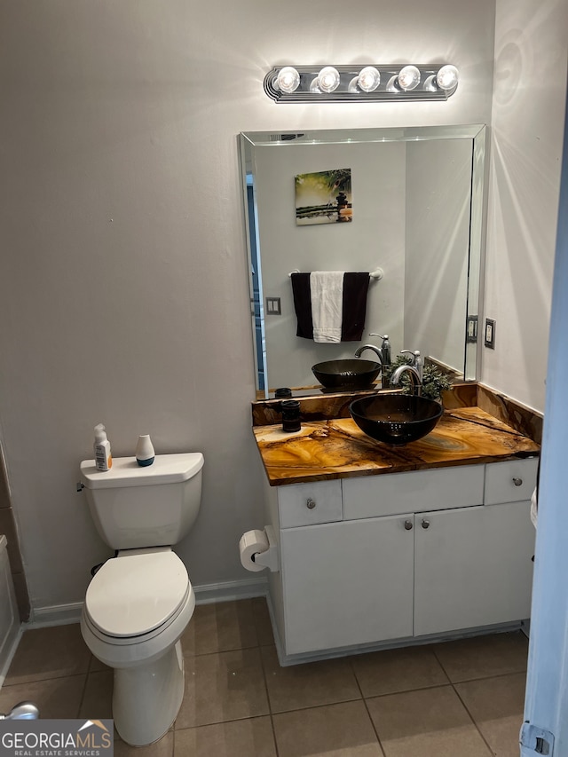 bathroom featuring tile patterned floors, vanity, and toilet