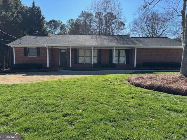 ranch-style house with brick siding and a front yard