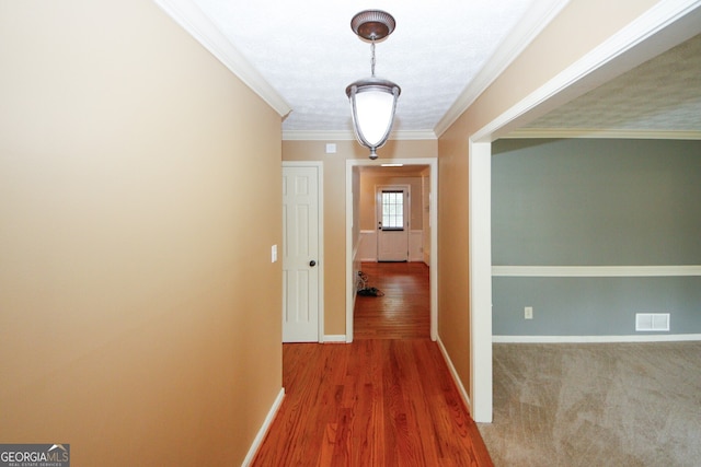 hallway featuring hardwood / wood-style flooring and crown molding