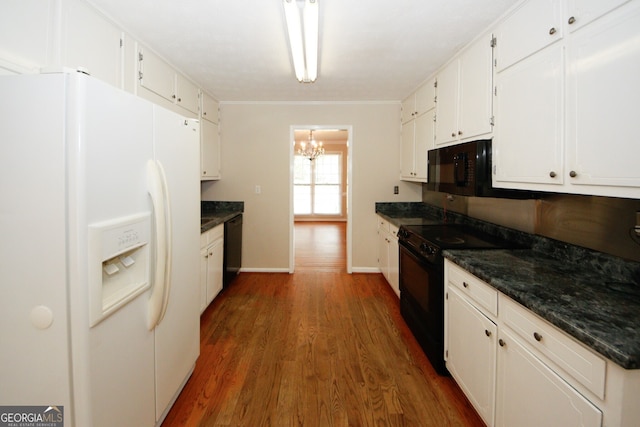 kitchen with a chandelier, dark stone countertops, dark hardwood / wood-style floors, black appliances, and white cabinetry