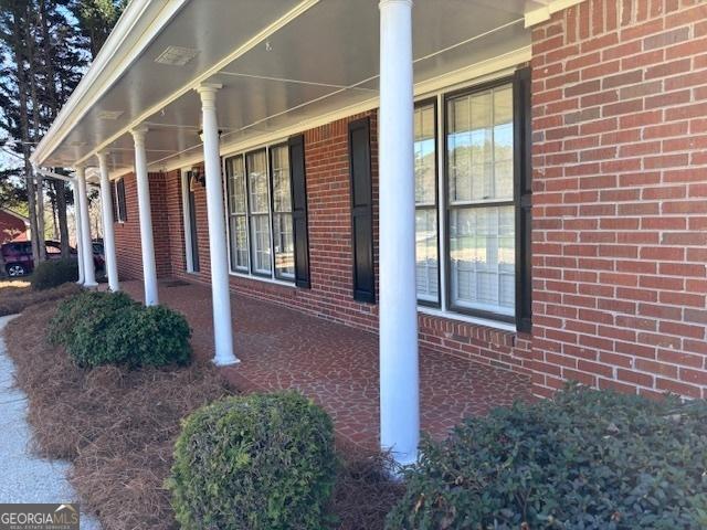 single story home featuring a porch and a front lawn