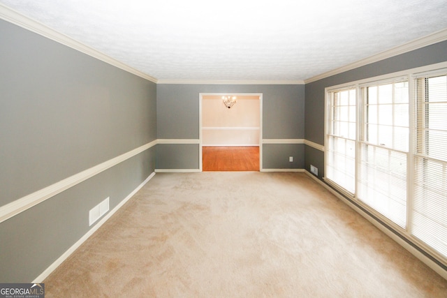 carpeted spare room featuring ornamental molding and a notable chandelier