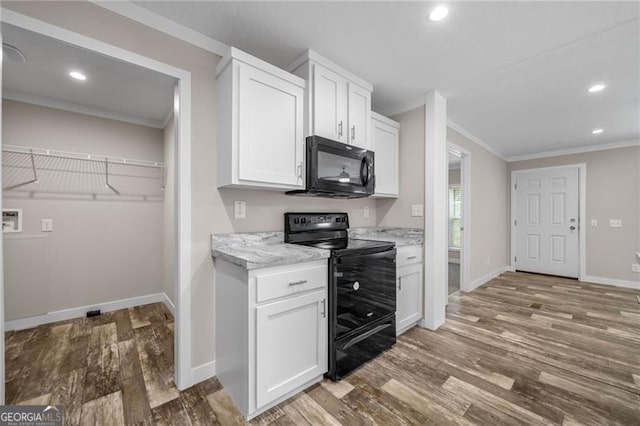 kitchen featuring black appliances, crown molding, hardwood / wood-style floors, and white cabinets