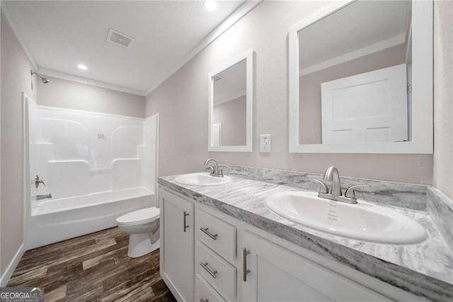 full bathroom with vanity, ornamental molding, hardwood / wood-style flooring, bathing tub / shower combination, and toilet