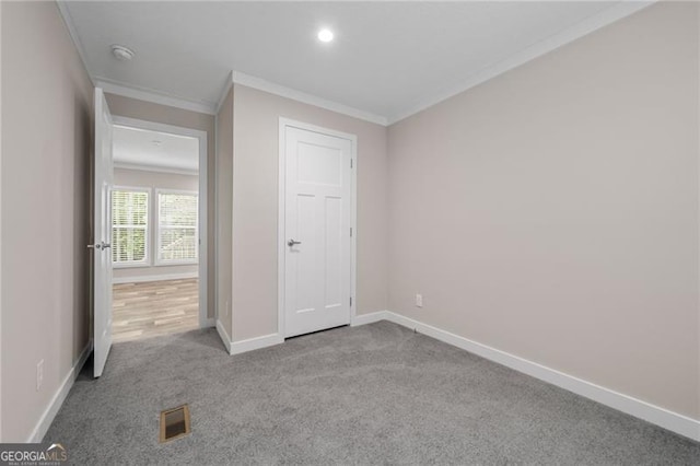 unfurnished bedroom with ornamental molding and light colored carpet