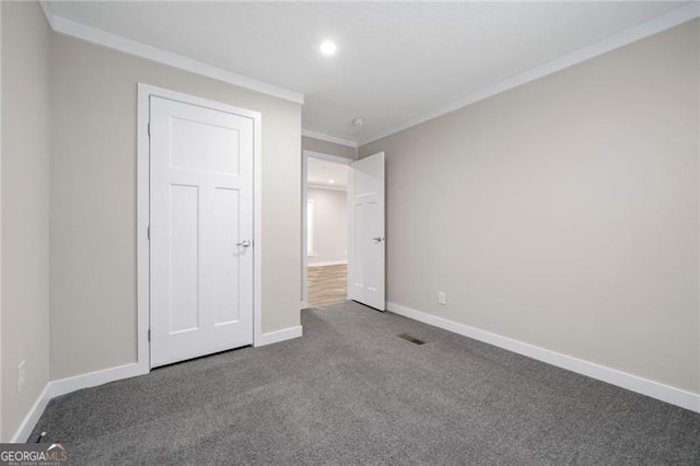 unfurnished bedroom with ornamental molding and carpet