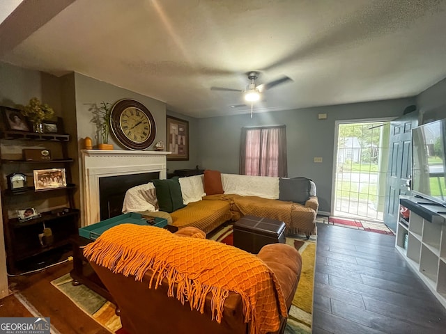 living room featuring ceiling fan and dark hardwood / wood-style floors