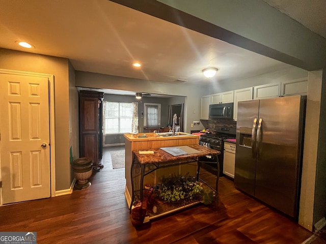 kitchen with tasteful backsplash, sink, white cabinetry, black appliances, and dark hardwood / wood-style flooring