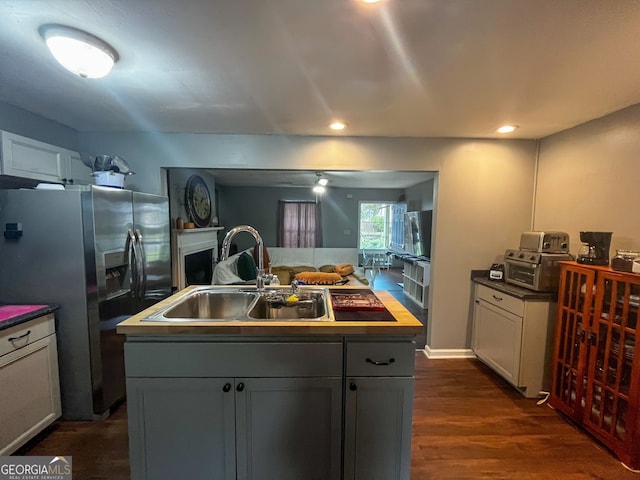 kitchen featuring gray cabinets, a center island with sink, stainless steel fridge with ice dispenser, and sink