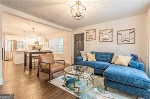 living room featuring an inviting chandelier and wood-type flooring