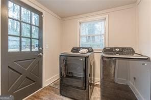 laundry area featuring crown molding, independent washer and dryer, and plenty of natural light