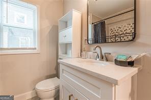 bathroom with vanity, toilet, and curtained shower