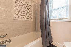 bathroom featuring shower / bath combo and toilet