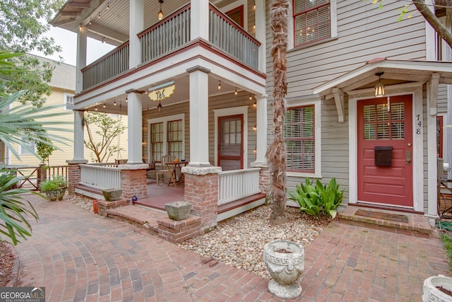 property entrance featuring a balcony and a patio area