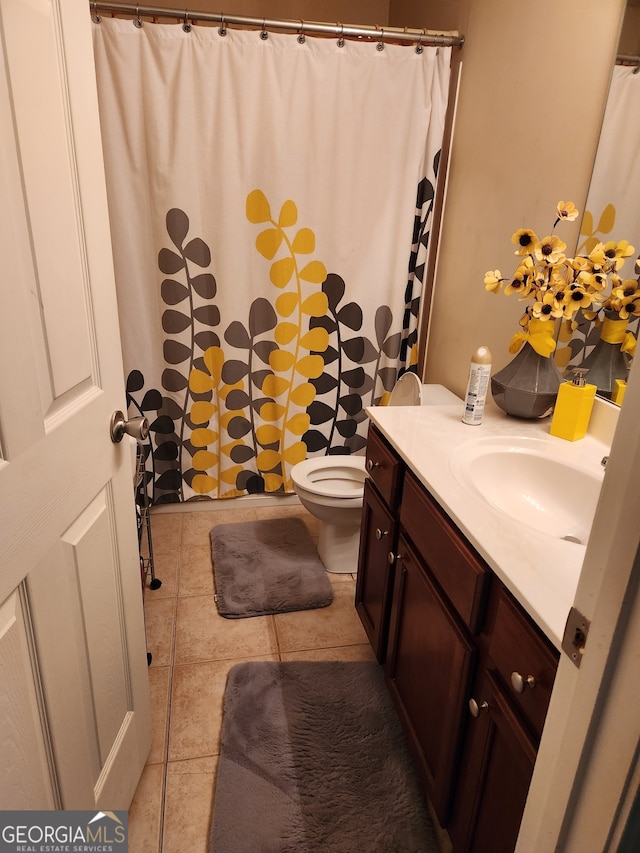 bathroom with a shower with shower curtain, tile patterned floors, vanity, and toilet