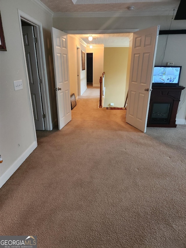 unfurnished living room featuring crown molding, baseboards, and light carpet