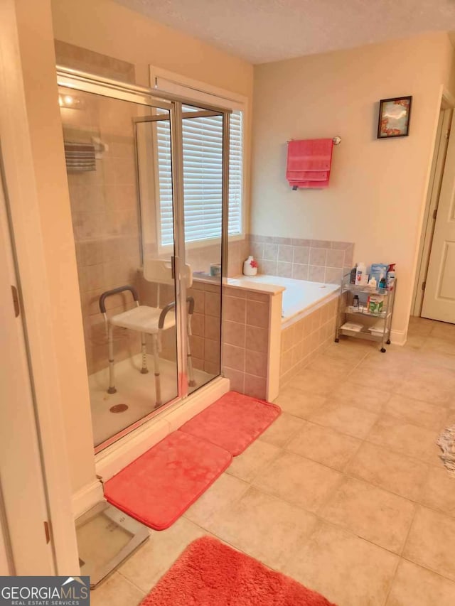 full bath featuring tile patterned floors, a shower stall, and a garden tub
