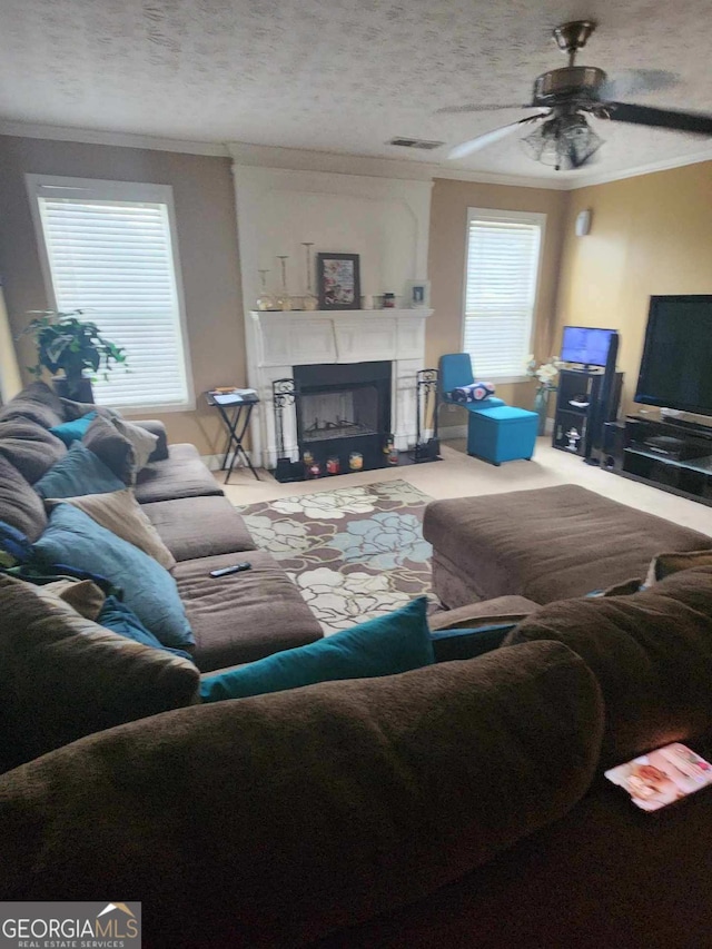 living room with a fireplace, visible vents, ornamental molding, and a ceiling fan