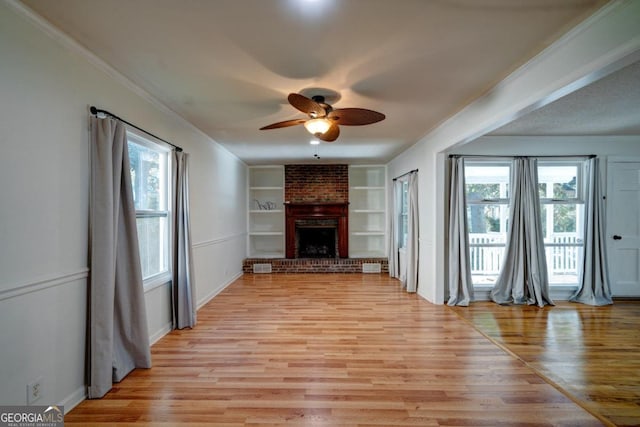 unfurnished living room featuring light hardwood / wood-style flooring, a healthy amount of sunlight, and built in features