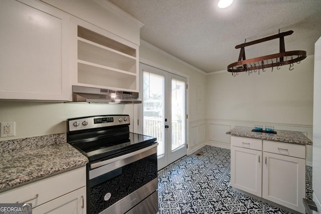 kitchen featuring electric stove, white cabinets, a textured ceiling, and wall chimney exhaust hood