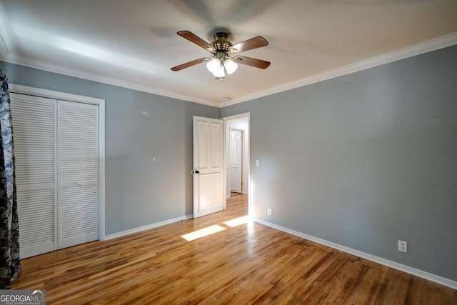 unfurnished bedroom with light hardwood / wood-style flooring, a closet, ceiling fan, and crown molding