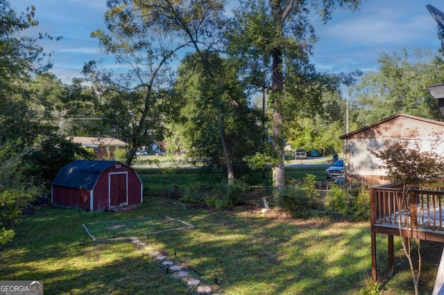 view of yard featuring a storage unit and a wooden deck