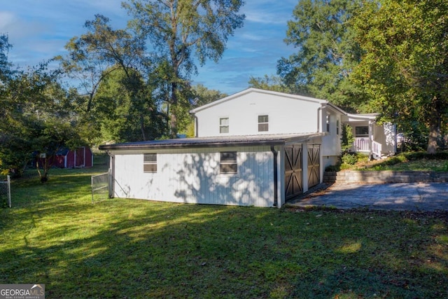 back of property with a lawn and a storage shed