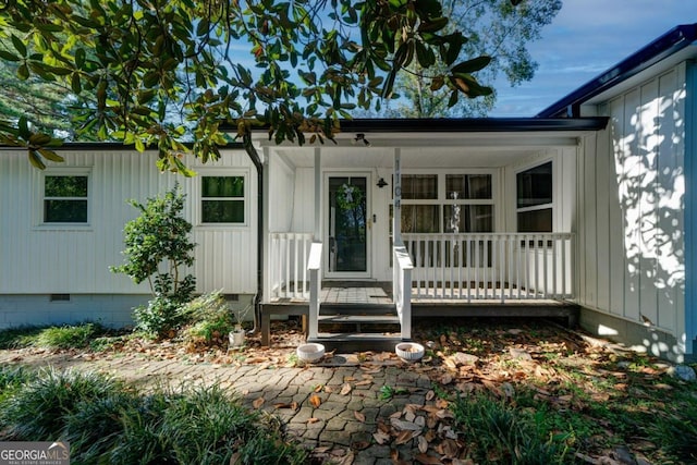 view of exterior entry featuring covered porch