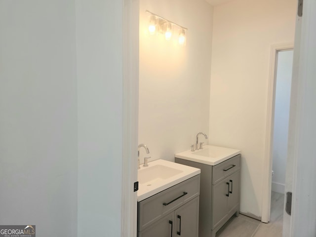 bathroom featuring two vanities, a sink, and tile patterned floors