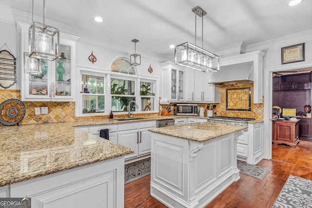 kitchen with white cabinetry, dark wood-type flooring, pendant lighting, a center island, and sink