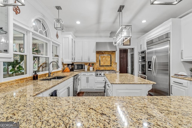 kitchen featuring stainless steel appliances, hanging light fixtures, sink, and white cabinetry