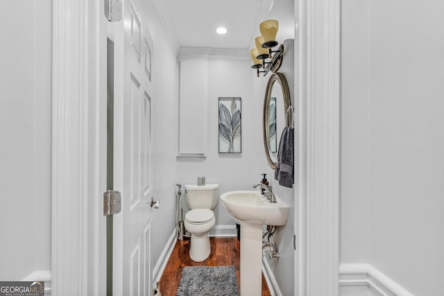 bathroom featuring ornamental molding, wood-type flooring, and toilet