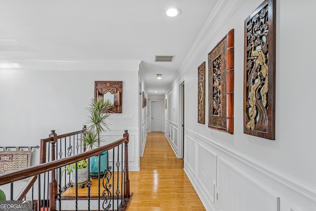 hallway with light hardwood / wood-style flooring and crown molding