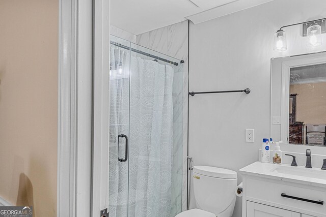 bathroom featuring walk in shower, vanity, and toilet