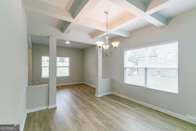 unfurnished dining area featuring beam ceiling, light wood-type flooring, and coffered ceiling